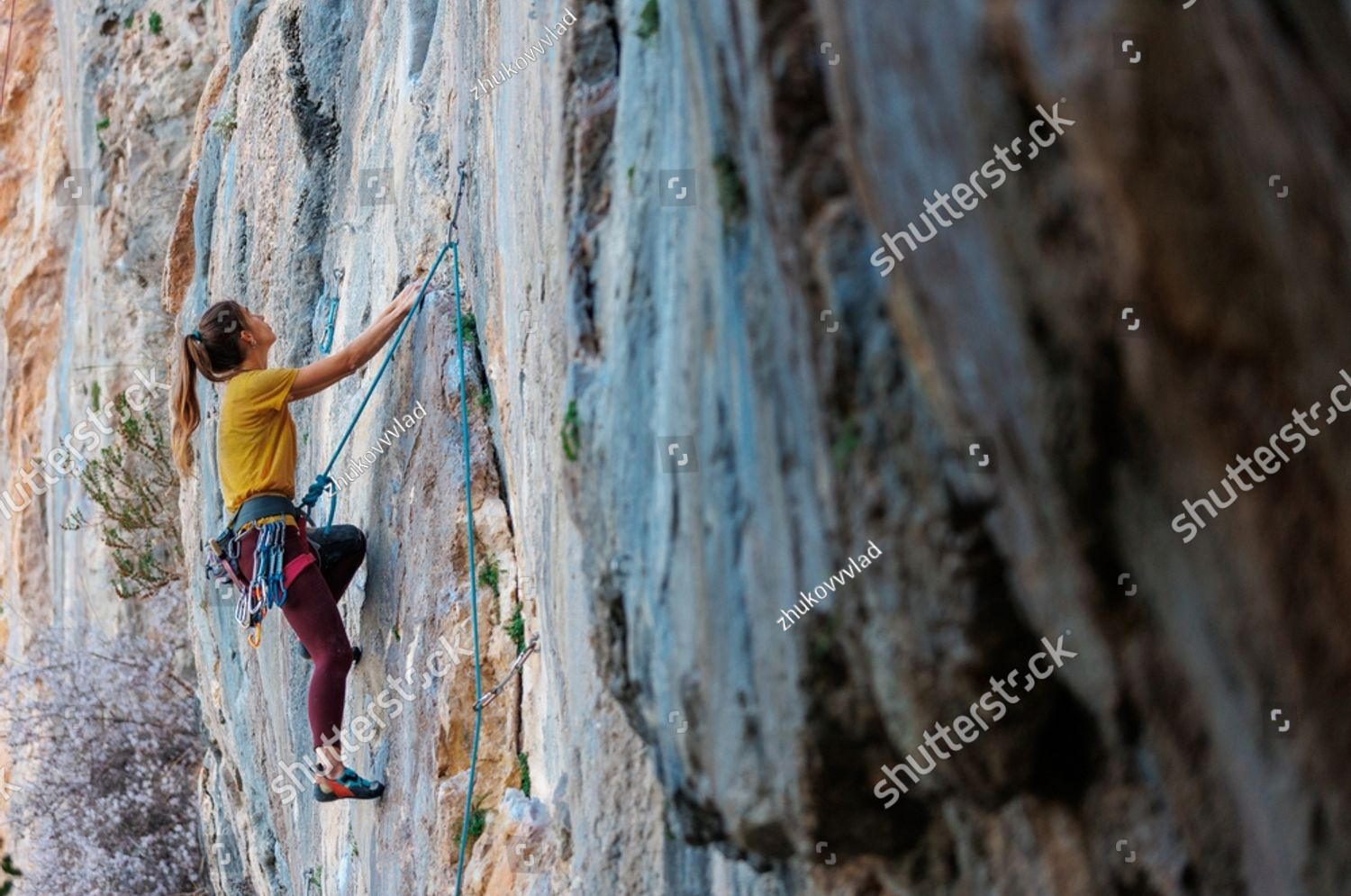 stock-photo-climber-overcomes-challenging-climbing-route-a-girl-climbs-a-rock-woman-engaged-in-e